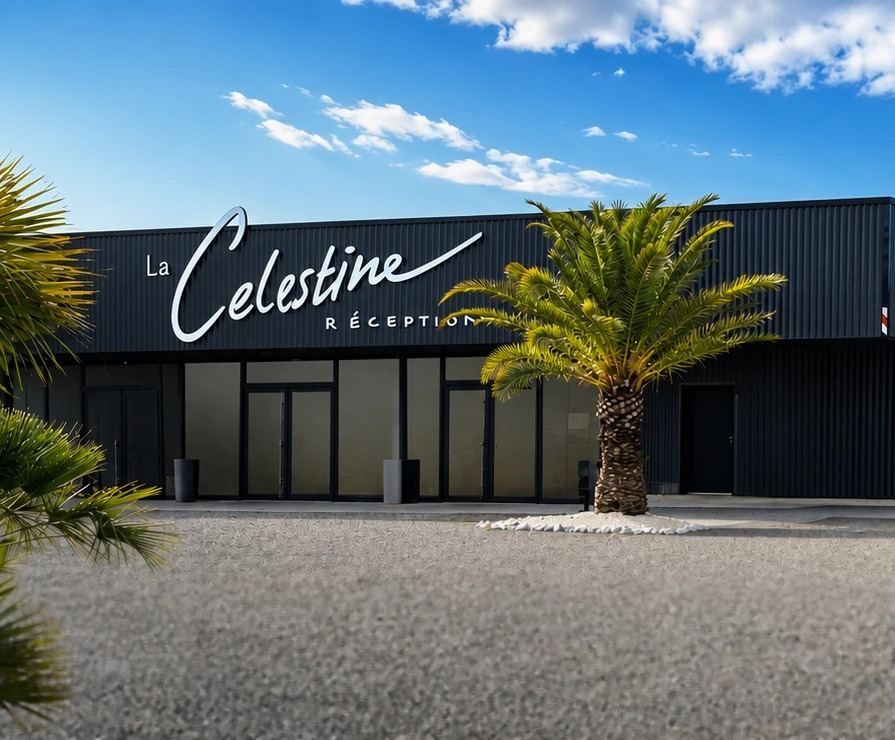 La façade de La Célestine sous un ciel bleu, avec un palmier et un parvis de gravier