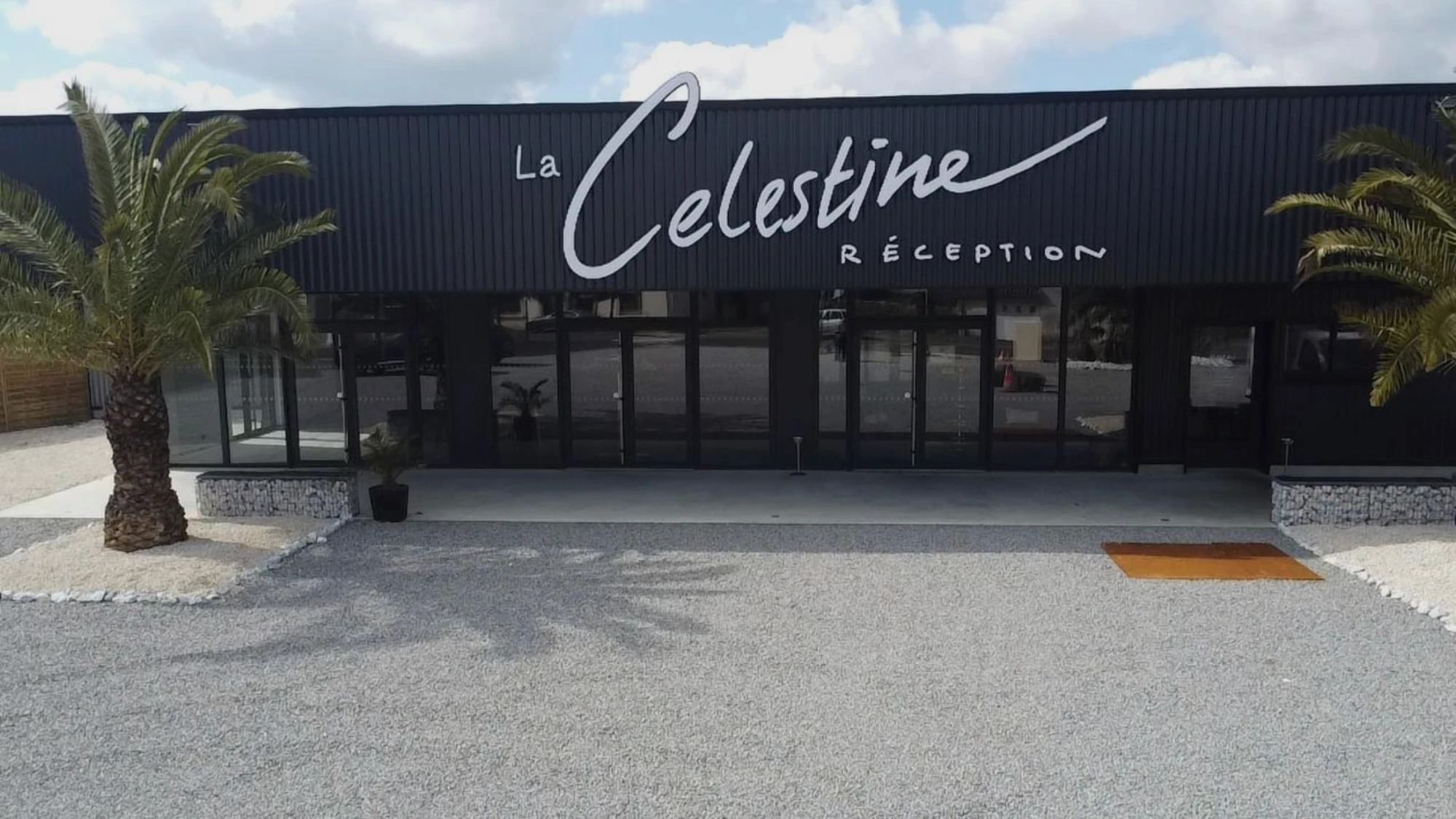 La façade de La Célestine en plein jour, encadrée de palmiers